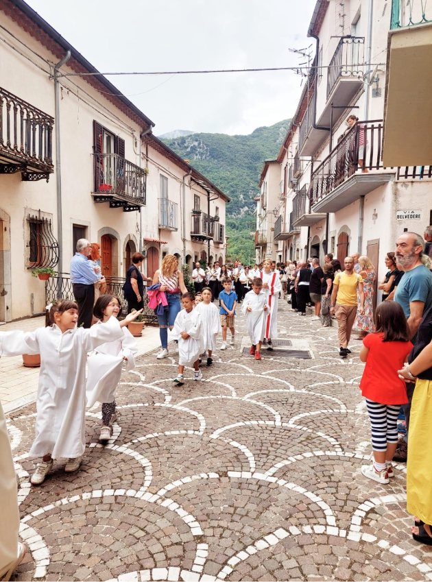 I chierichetti aprono la processione di San Nicola lungo la strada acciottolata del borgo